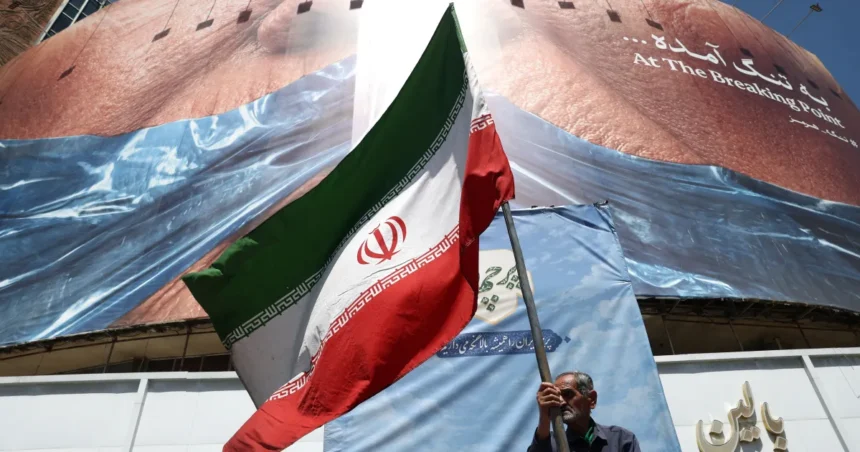 Homem-segura-bandeira-iraniana-perto-de-outdoor-anti-eua-representando-o-presidente-dos-eua-donald-twebp - Podp Bahia